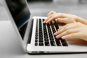 Femme qui tape sur le clavier d'un ordinateur